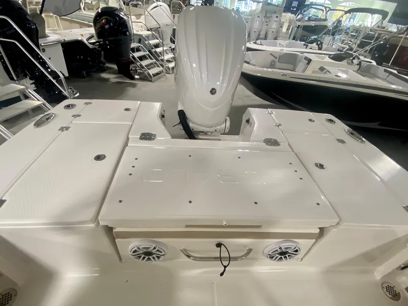 Slide: The Image of 2026 Robalo 246 Cayman boat interior with engine, storage, and speakers in showroom. - 6