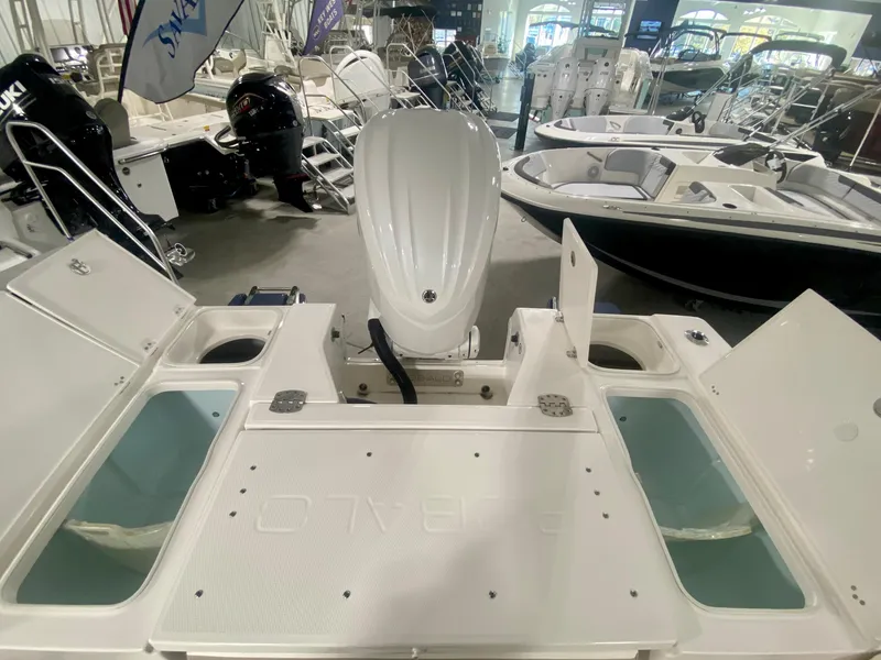 Slide: The Image of 2026 Robalo 246 Cayman boat interior with open compartments and outboard motor in showroom. - 7