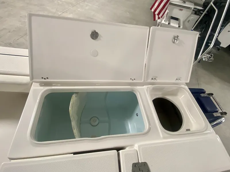 Slide: The Image of 2026 Robalo 246 Cayman boat storage compartments with open lids, showcasing interior design. - 8