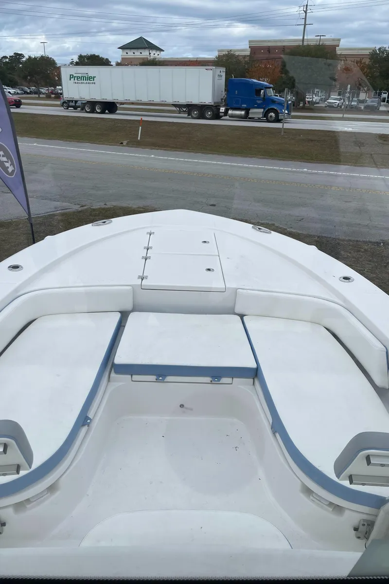 Slide: The Image of 2026 Robalo 246 Cayman boat bow view with highway and truck in background. - 13