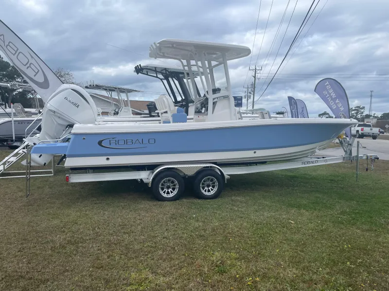 The Image of 2026 Robalo 246 Cayman boat on trailer, displayed outdoors under cloudy sky. - 0
