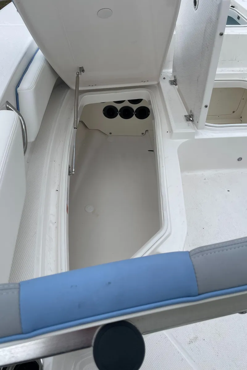 Slide: The Image of 2026 Robalo 246 Cayman boat storage compartment with open hatch and seating area. - 15