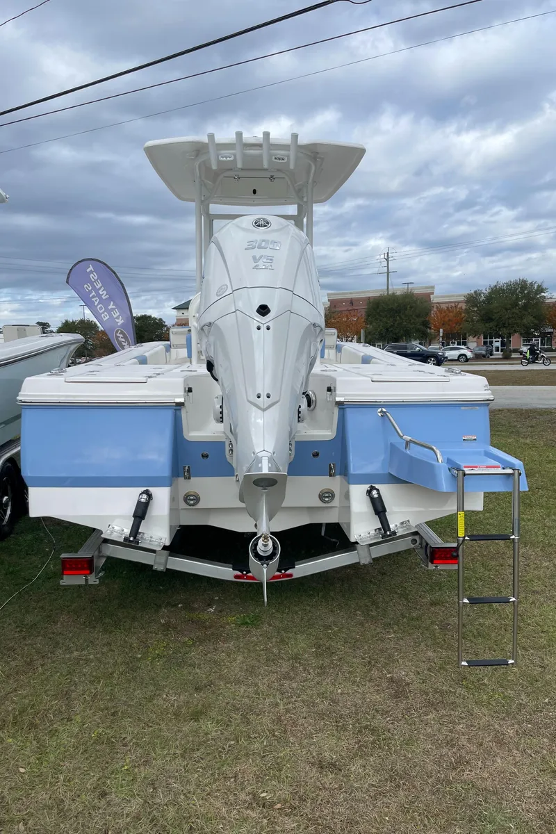 Slide: The Image of 2026 Robalo 246 Cayman boat displayed outdoors, featuring a sleek design and outboard motor. - 2