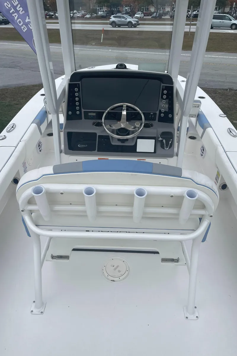Slide: The Image of 2026 Robalo 246 Cayman boat interior with steering console and rod holders. - 7