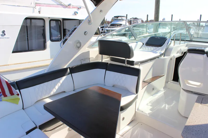 Slide: The Image of 2014 Sea Ray 350 Sundancer boat interior with seating and table. - 13