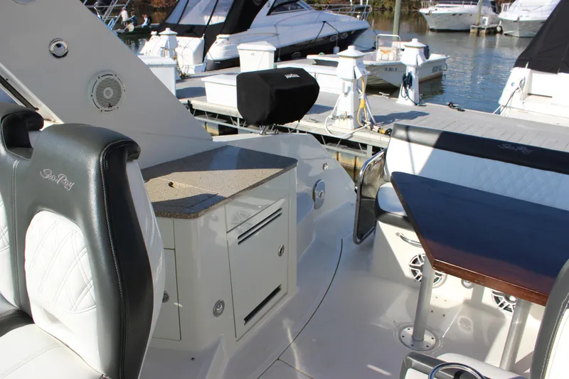 Slide: The Image of 2014 Sea Ray 350 Sundancer cockpit with seating and storage, docked at marina. - 19