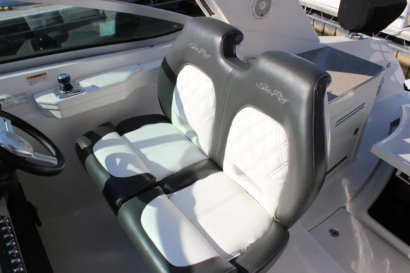 Slide: The Image of 2014 Sea Ray 350 Sundancer cockpit with dual leather seats and steering wheel. - 24