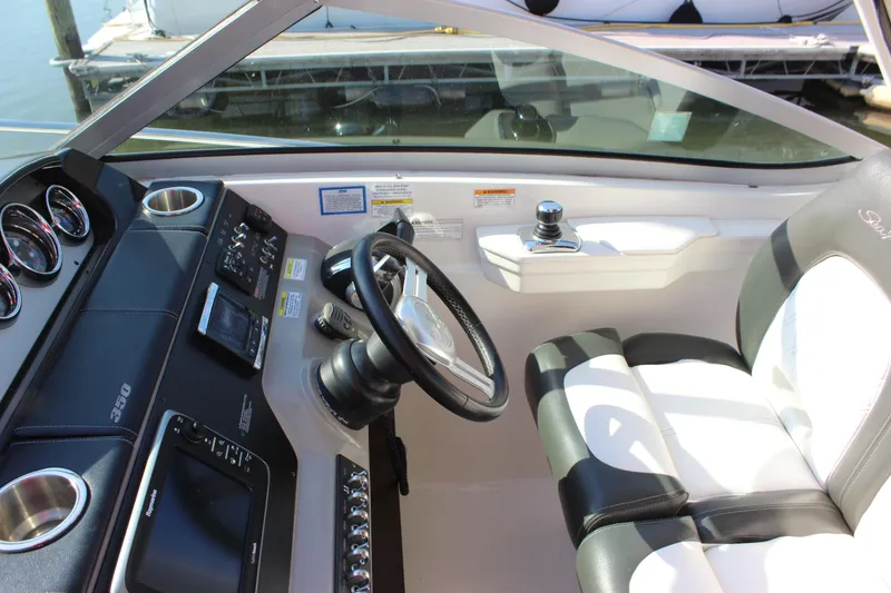 Slide: The Image of 2014 Sea Ray 350 Sundancer helm with steering wheel and control panel. - 25