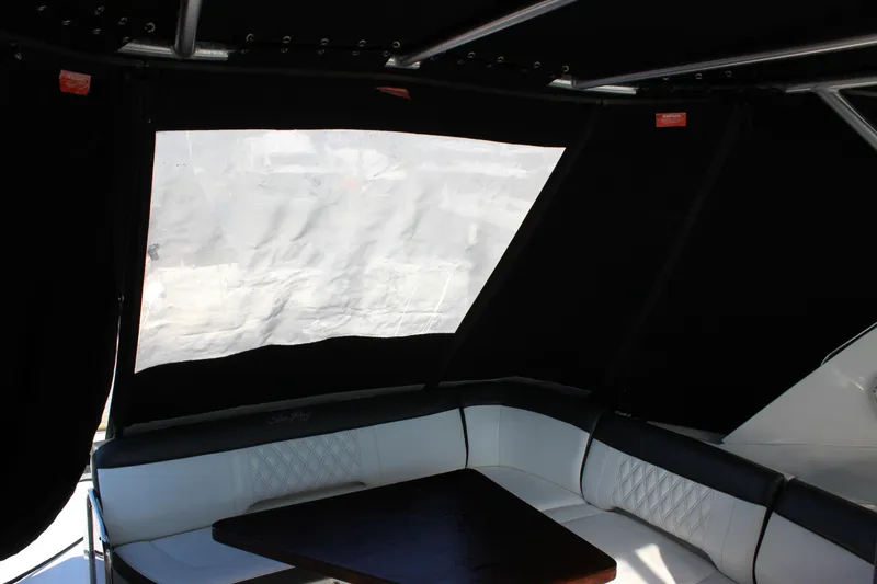 Slide: The Image of Interior of 2014 Sea Ray 350 Sundancer with black canopy and white seating. - 35