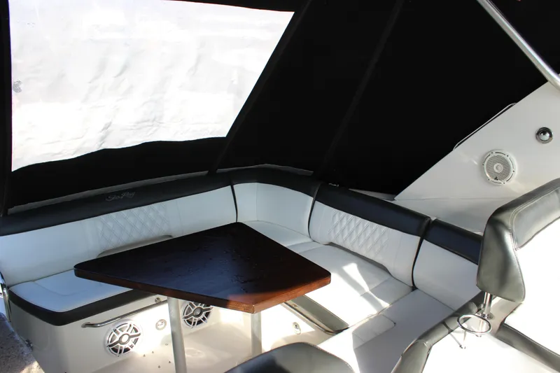 Slide: The Image of 2014 Sea Ray 350 Sundancer interior with white seating and wooden table. - 38