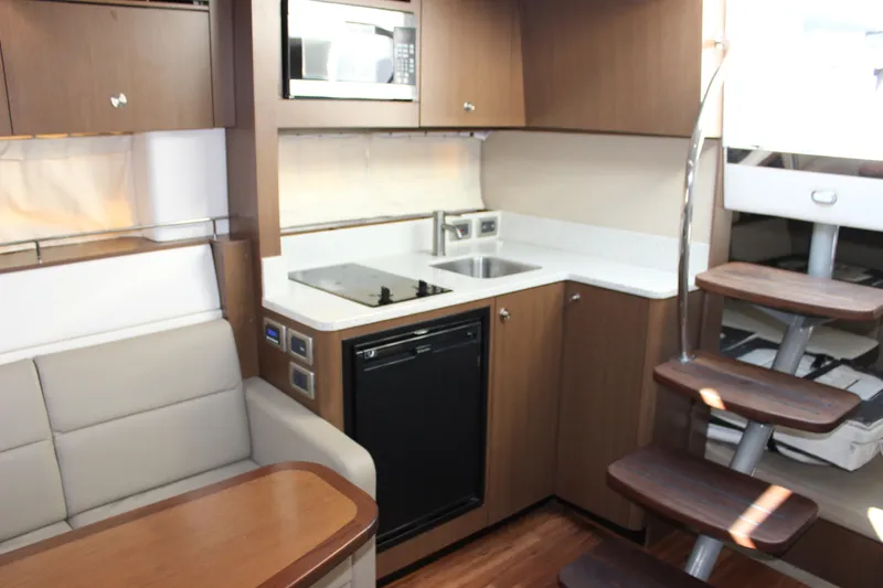 Slide: The Image of Interior of 2014 Sea Ray 350 Sundancer yacht with kitchenette and seating area. - 40