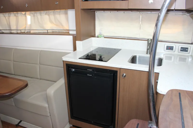 Slide: The Image of Interior of 2014 Sea Ray 350 Sundancer with kitchenette and seating area. - 46