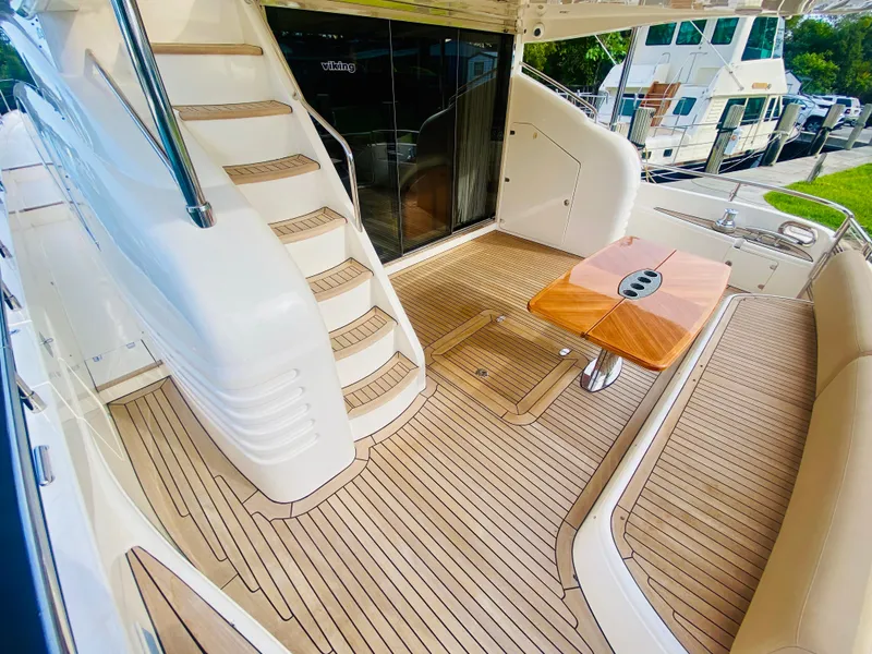 Slide: The Image of 2006 Viking Sport Cruisers 70 Motor Yacht aft deck with teak flooring and seating area. - 12