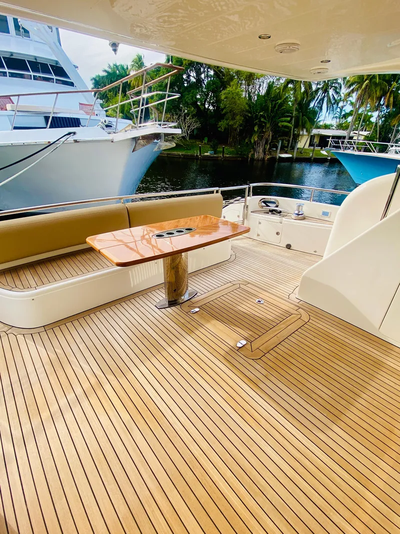 Slide: The Image of 2006 Viking Sport Cruisers 70 Motor Yacht aft deck with teak flooring and seating area. - 14