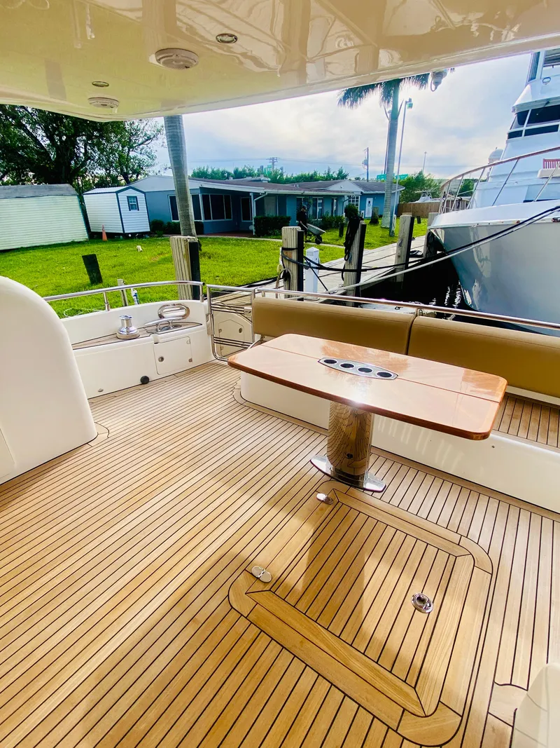 Slide: The Image of 2006 Viking Sport Cruisers 70 Motor Yacht aft deck with teak flooring and dining table. - 15