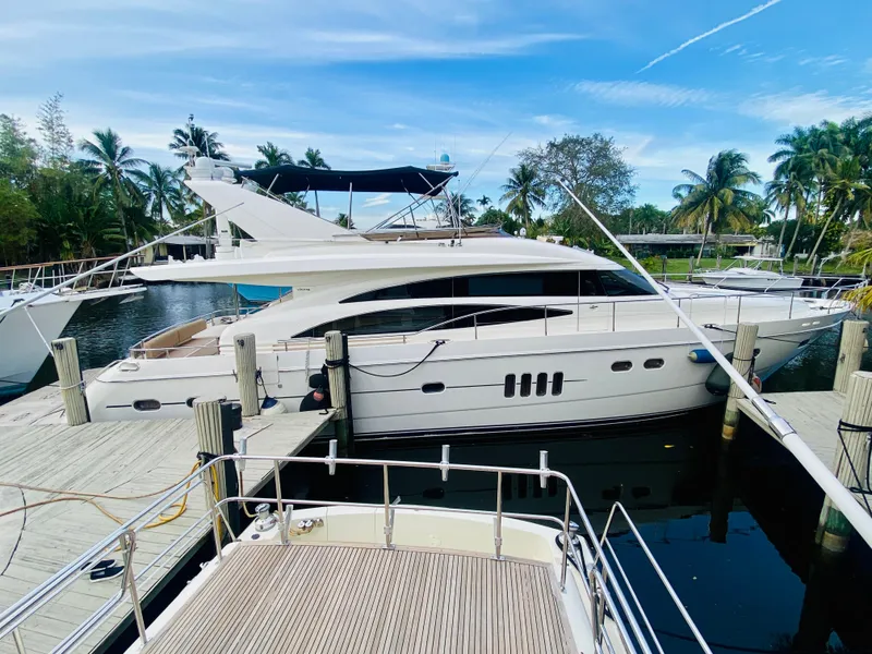 Slide: The Image of 2006 Viking Sport Cruisers 70 Motor Yacht docked at marina with palm trees. - 2