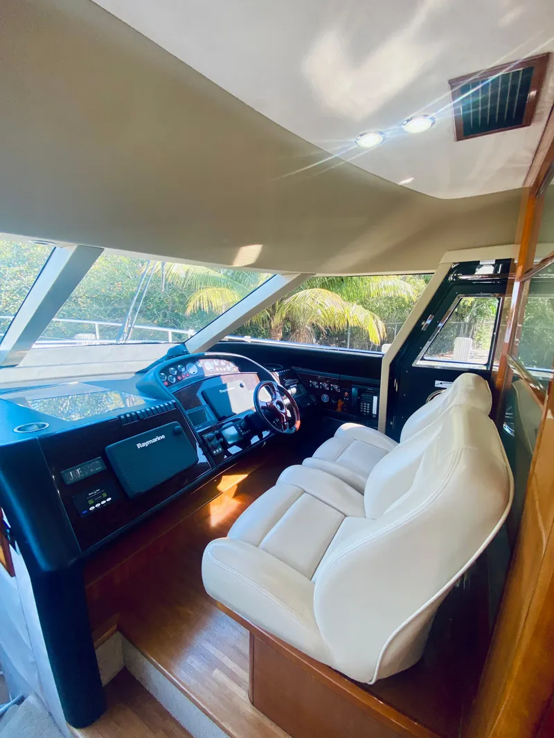Slide: The Image of Interior helm of 2006 Viking Sport Cruisers 70 Motor Yacht with white leather seats. - 44