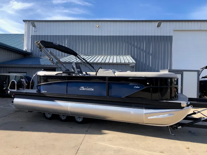 The Image of 2024 Barletta Cabrio 20Q pontoon boat parked outside a warehouse. - 1