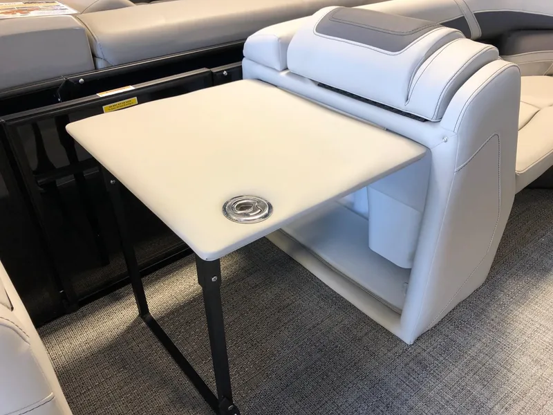 Slide: The Image of 2024 Barletta Cabrio 20Q boat interior with foldable table and cushioned seating. - 16