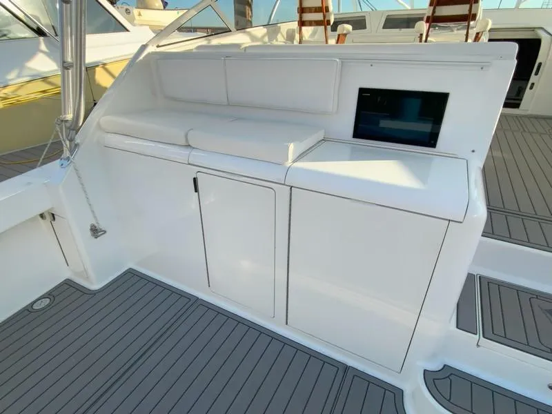 Slide: The Image of 2005 Viking 45 Open Express boat interior with white cabinetry and cushioned seating. - 15