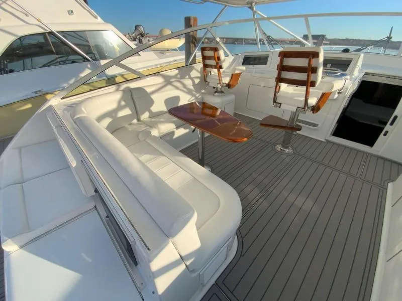 Slide: The Image of 2005 Viking 45 Open Express yacht with spacious seating and wooden table. - 21