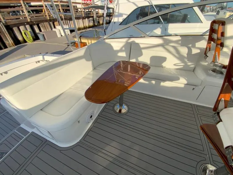 Slide: The Image of 2005 Viking 45 Open Express boat with white seating and wooden table. - 25