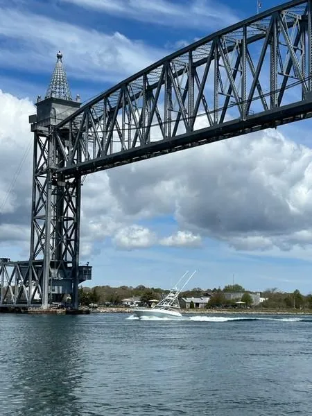 Slide: The Image of 2005 Viking 45 Open Express boat passing under a large steel bridge on a sunny day. - 3