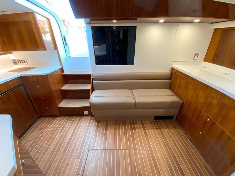 Slide: The Image of 2005 Viking 45 Open Express yacht interior with wooden cabinetry and beige sofa. - 48