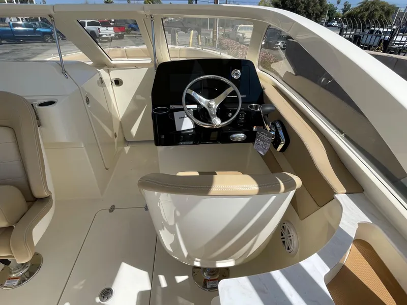 Slide: The Image of 2024 Scout 240 Dorado boat interior with steering wheel and seating. - 15