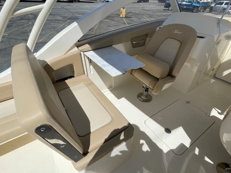Slide: The Image of 2024 Scout 240 Dorado boat interior with beige seating and a small table. - 16