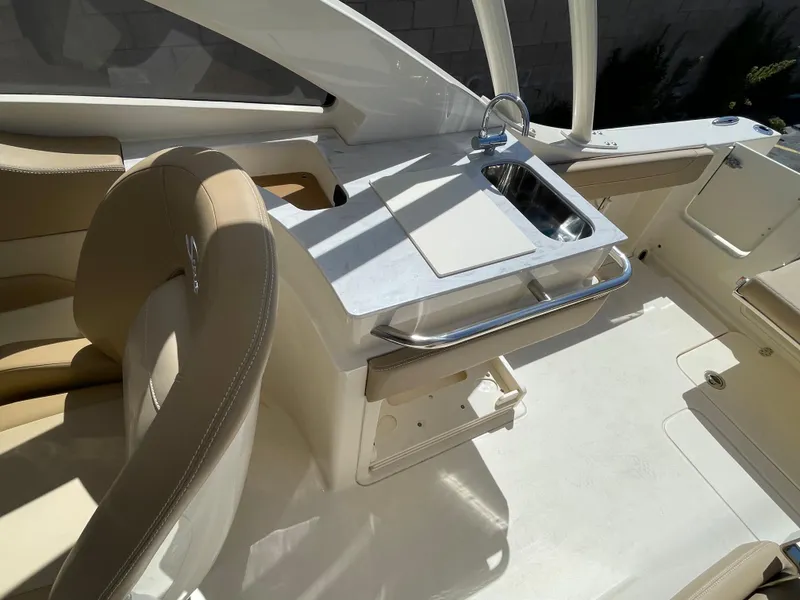 Slide: The Image of 2024 Scout 240 Dorado boat interior with sink and seating area. - 19