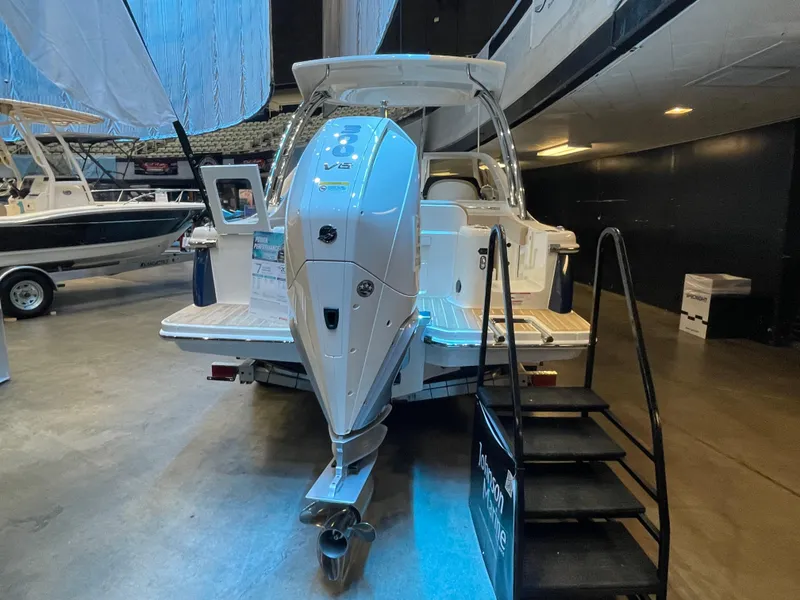 Slide: The Image of 2024 Scout 240 Dorado boat with outboard motor on display indoors. - 2