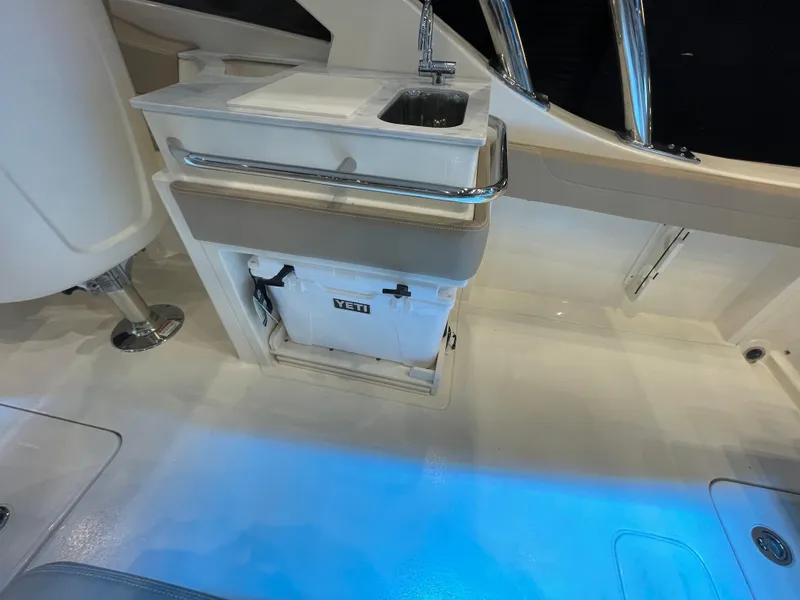 Slide: The Image of 2024 Scout 240 Dorado boat interior with sink and YETI cooler. - 5