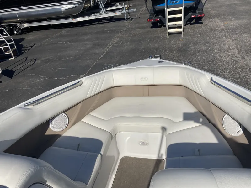 Slide: The Image of 2007 Cobalt 212 boat interior with white seating and speakers, parked on asphalt. - 13
