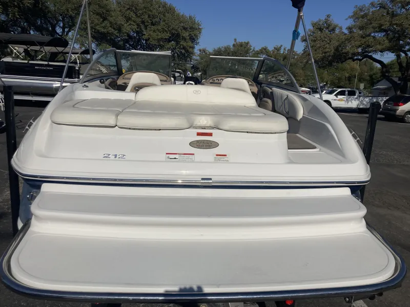 Slide: The Image of 2007 Cobalt 212 boat with white seating and swim platform, parked outdoors. - 2