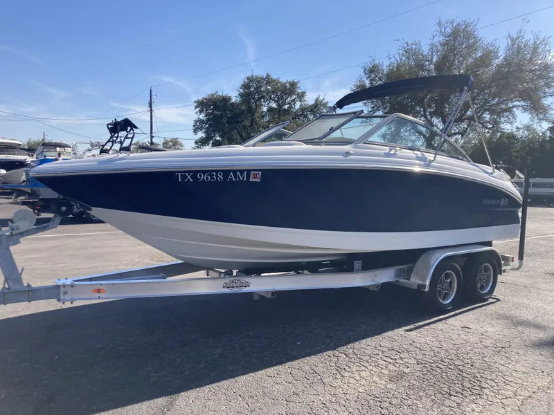 Slide: The Image of 2007 Cobalt 212 boat on trailer, blue and white, parked outdoors. - 4