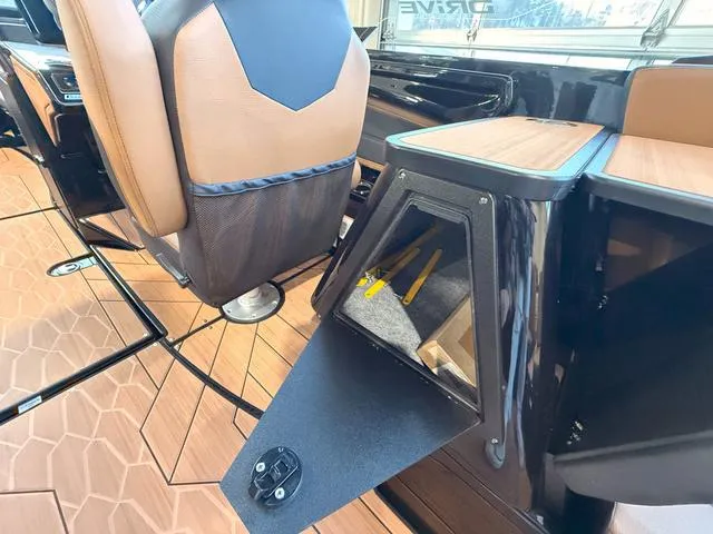 Slide: The Image of 2025 Yamaha Boats 255XD interior with open storage compartment and stylish seating. - 12