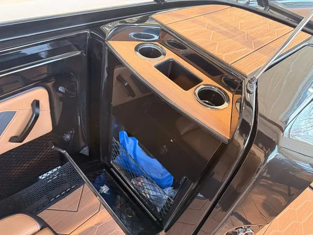 Slide: The Image of 2025 Yamaha Boats 255XD interior with cup holders and storage compartment. - 19