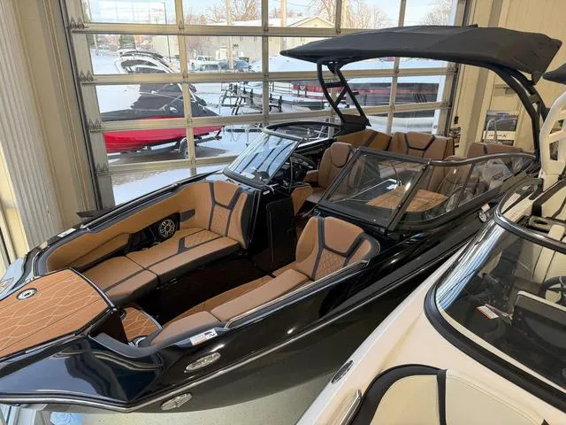 Slide: The Image of 2025 Yamaha Boats 255XD, sleek black design, luxurious tan interior, displayed indoors. - 3