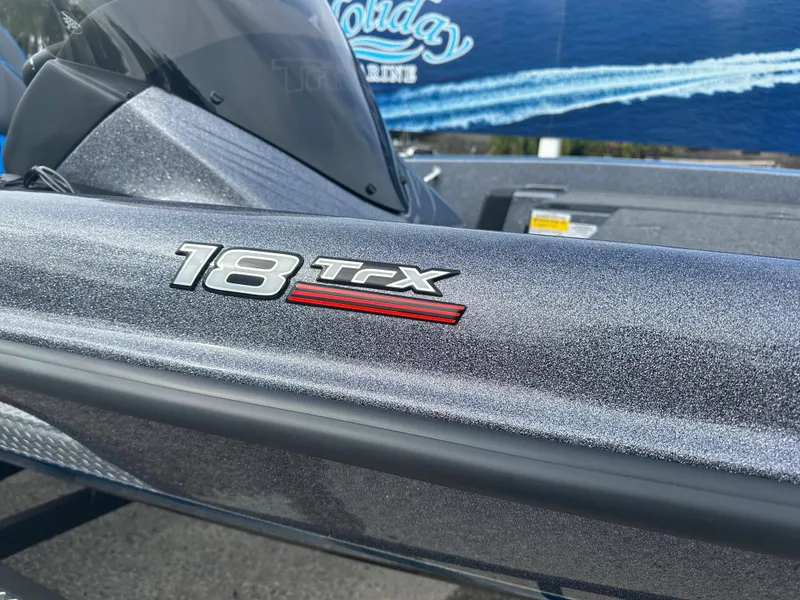 Slide: The Image of 2024 Triton 18 TrX boat close-up, metallic finish, model logo visible. - 4