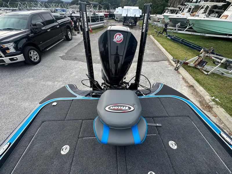 Slide: The Image of 2024 Triton 18 TrX bass boat with Mercury engine at marina. - 6