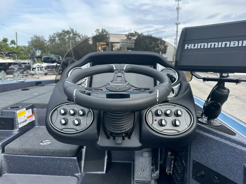 Slide: The Image of 2024 Triton 18 TrX boat dashboard with Humminbird fish finder and steering wheel. - 7