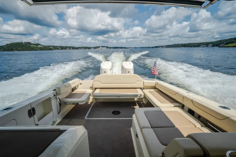 Slide: The Image of 2024 Chris-Craft Calypso 35 cruising on a lake, showcasing luxurious seating and powerful engines. - 27