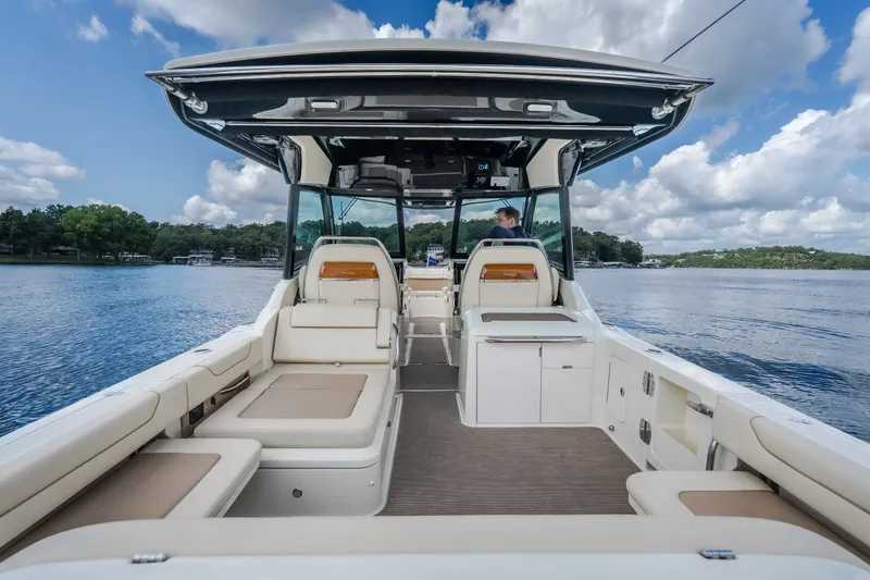 Slide: The Image of 2024 Chris-Craft Calypso 35 boat interior with seating, on a serene lake. - 10