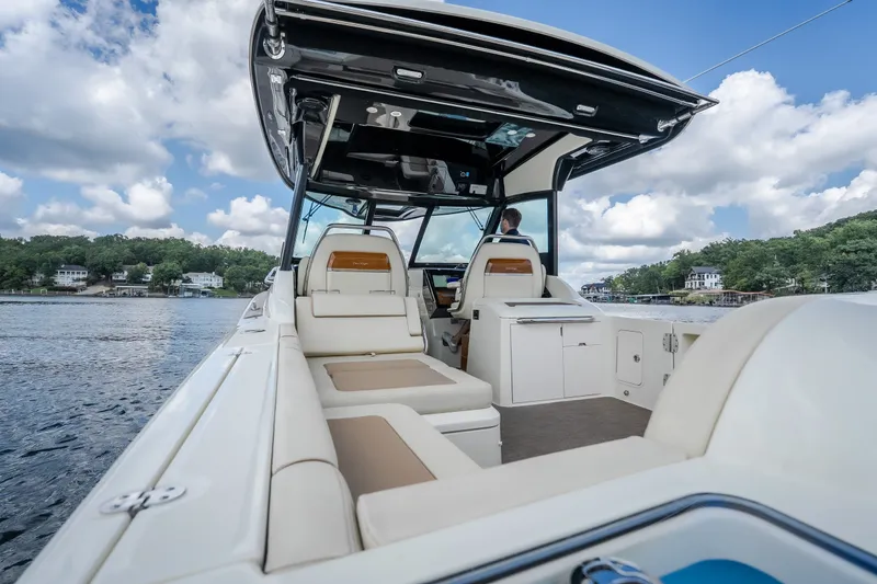 Slide: The Image of 2024 Chris-Craft Calypso 35 boat interior with luxurious seating on a scenic lake. - 11