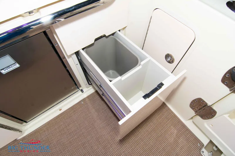 Slide: The Image of 2024 Chris-Craft CALYPSO 35 CP interior storage compartment with pull-out trash bin. - 28