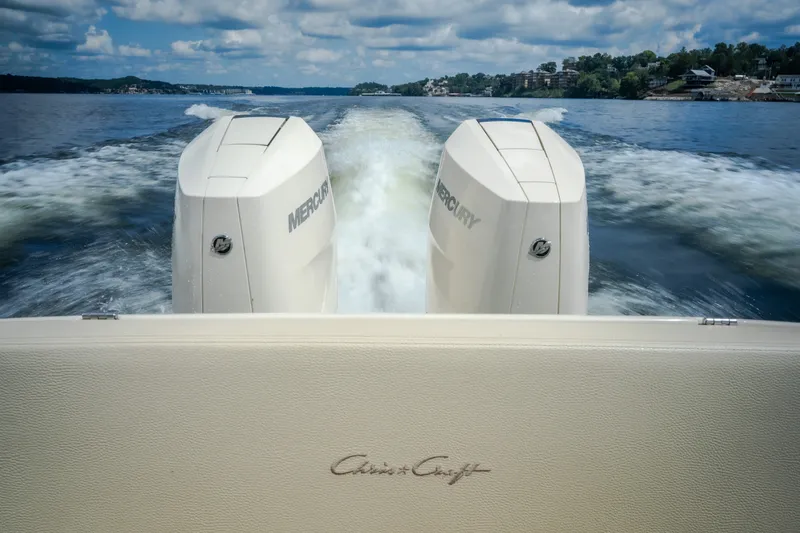 Slide: The Image of 2024 Chris-Craft Calypso 35 with dual Mercury engines cruising on a scenic lake. - 20