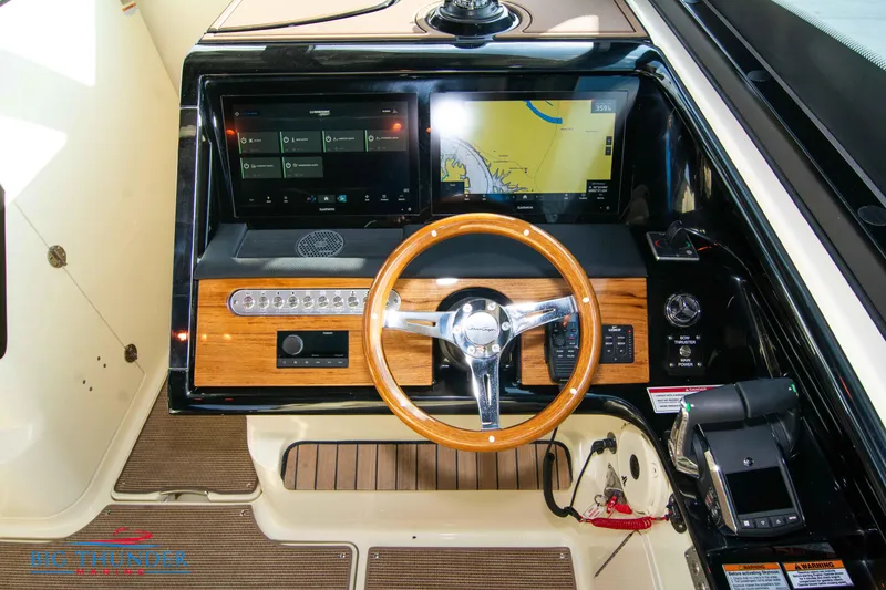 Slide: The Image of 2024 Chris-Craft CALYPSO 35 CP helm with modern navigation displays and wooden steering wheel. - 39