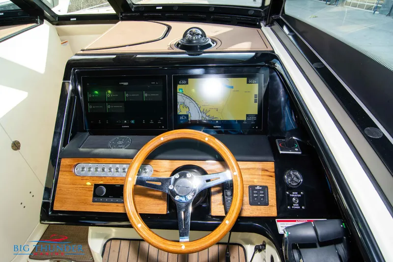 Slide: The Image of 2024 Chris-Craft CALYPSO 35 CP dashboard with wooden steering wheel and dual navigation screens. - 40