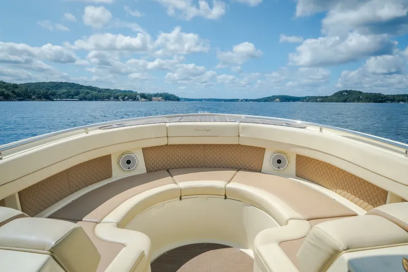 Slide: The Image of 2024 Chris-Craft Calypso 35 boat interior with luxurious seating on a scenic lake. - 46